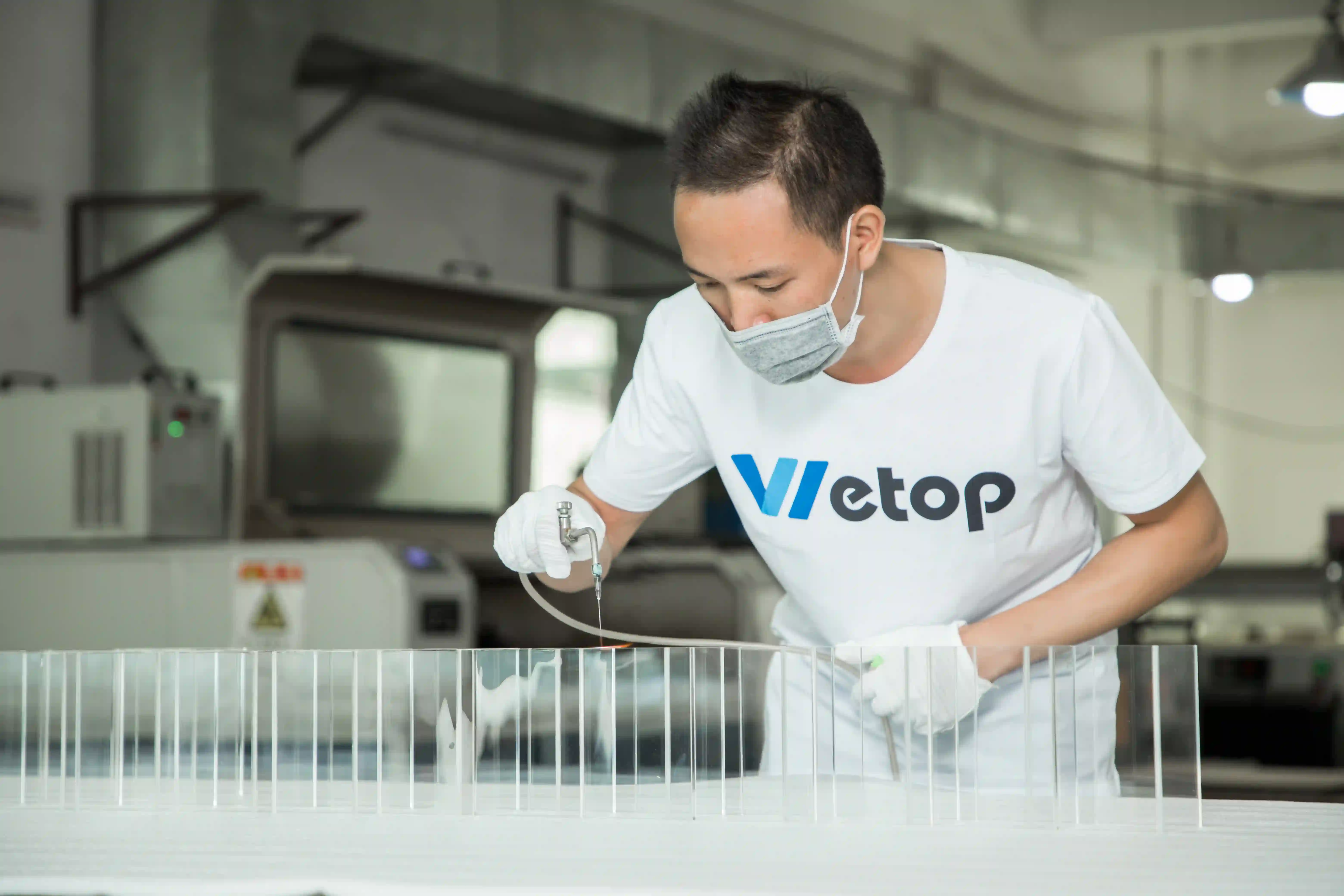 Wetop factory technician flame-polishing an acrylic edge to glass-clear finish