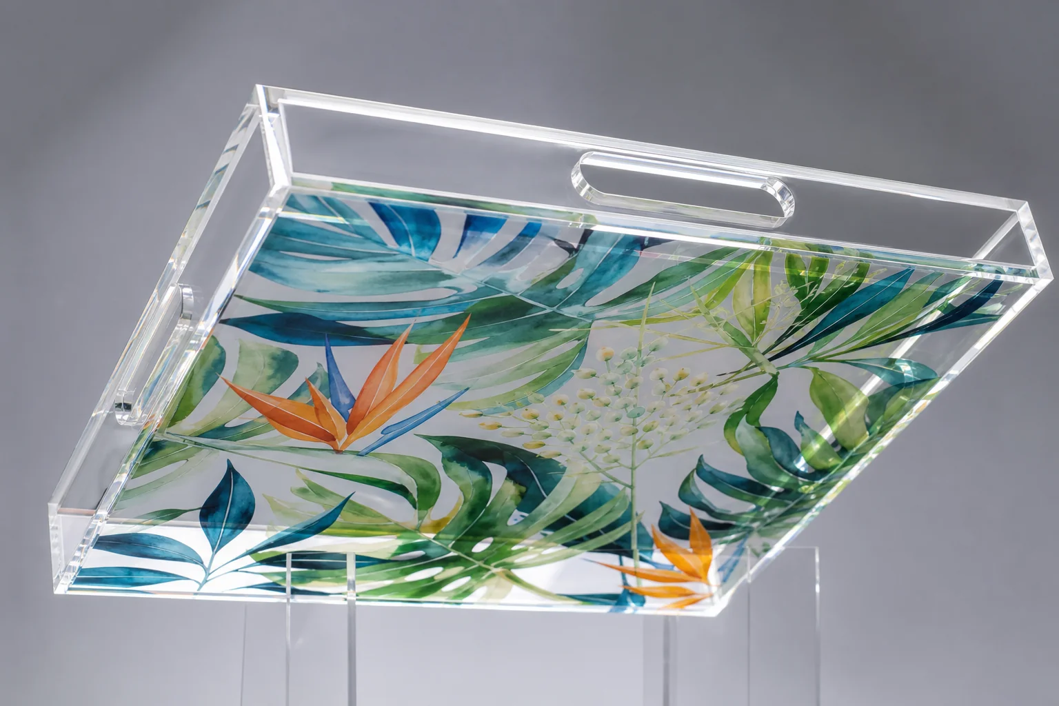 Clear acrylic tray tilted at 45 degrees showing vivid botanical artwork printed on the underside of the PMMA base