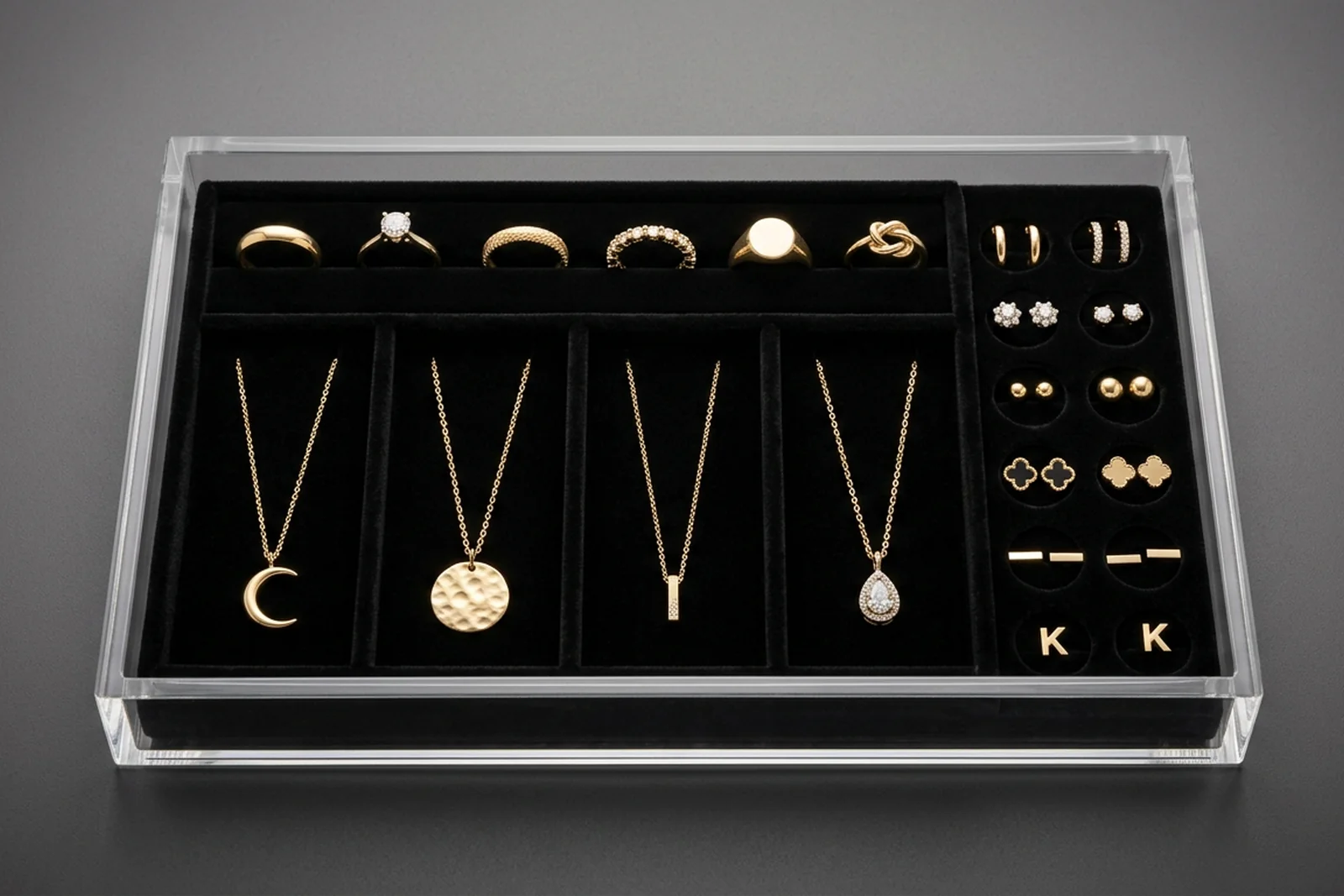Custom acrylic jewelry display tray with black velvet insert holding rings, pendant necklaces, and stud earrings in die-cut slots — retail jewelry merchandising with velvet-lined acrylic