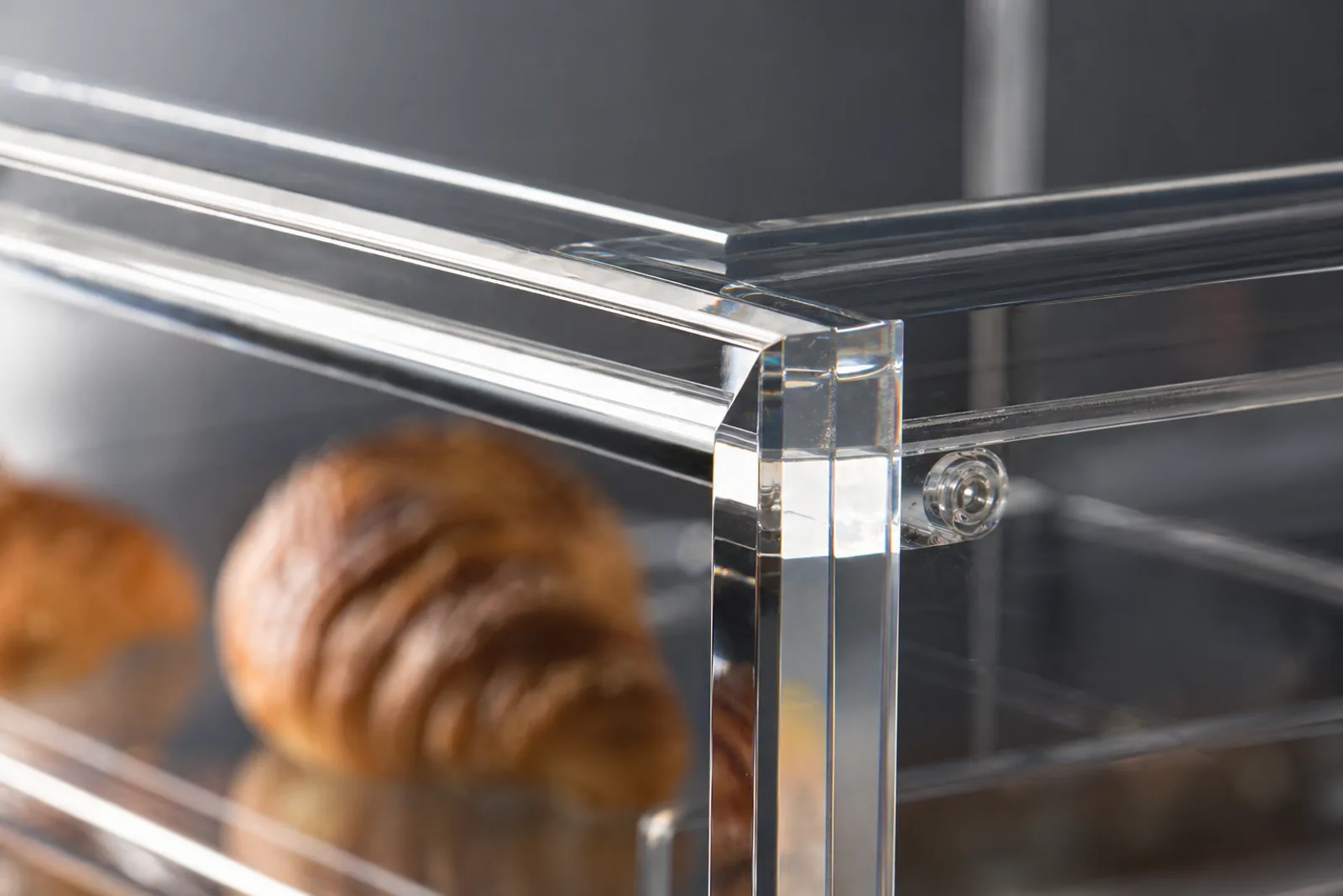 Macro close-up of a diamond-polished acrylic edge on a custom bakery display case showing optical clarity (PMMA plexiglass food-grade pastry showcase)