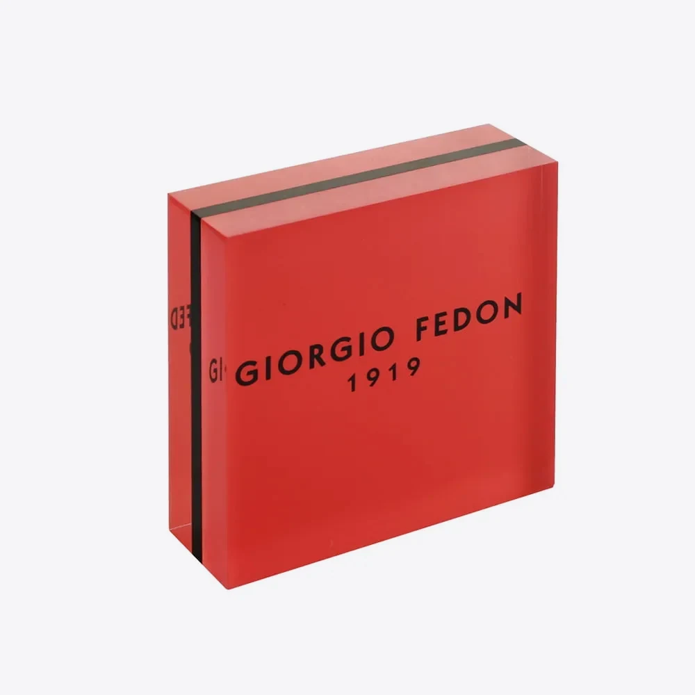 Red custom acrylic logo block with black surface-printed brand lettering and polished edges