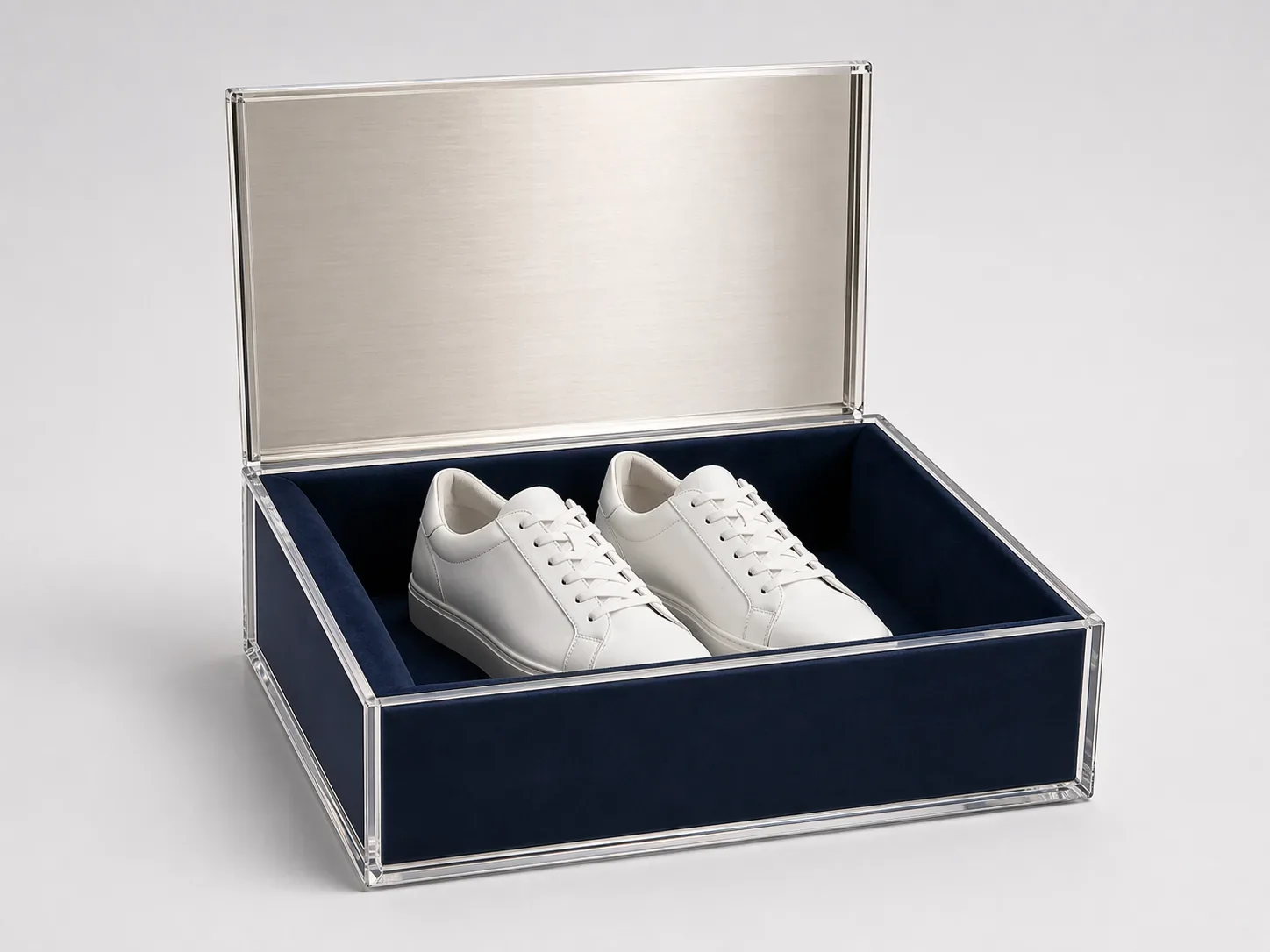 Luxury acrylic shoe box with mirrored lid, navy velvet lining, and white sneakers