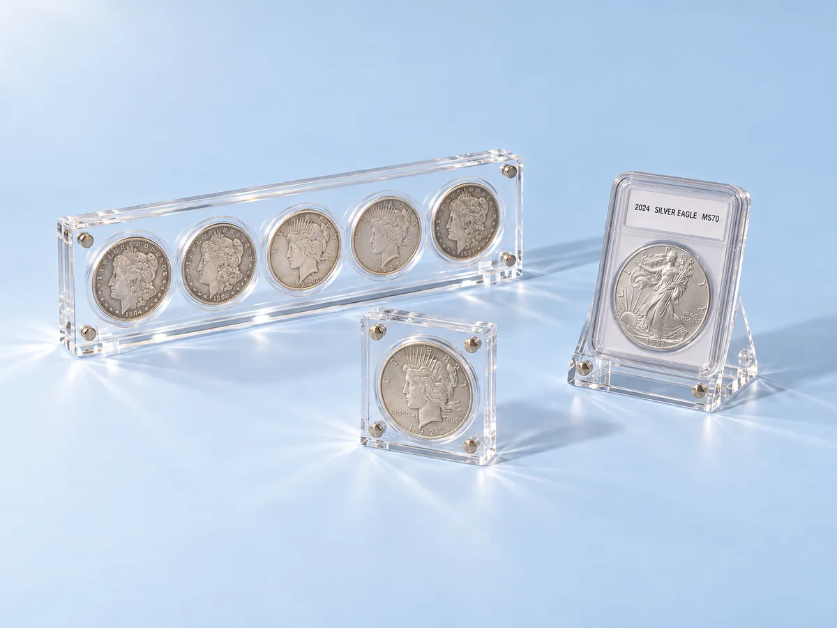 Coin display cases in clear acrylic: a five-coin silver dollar holder, a single-coin block and a graded coin easel stand