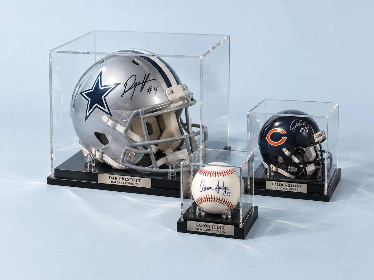 Sports memorabilia display cases: a signed football helmet case, a signed baseball cube and a mini helmet case
