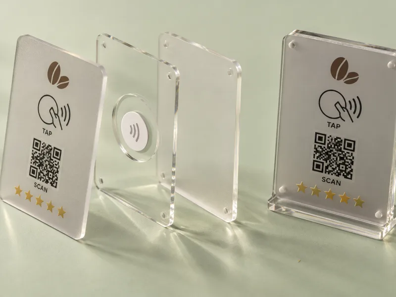 Exploded three-layer acrylic review plaque showing the NFC tag in the middle layer, beside the assembled plaque