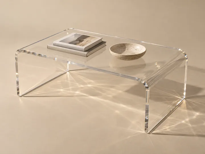 Clear cast acrylic coffee table with thick beveled edges in a hotel lobby