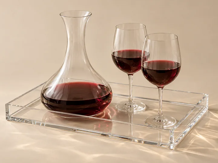 Handleless clear acrylic serving tray holding a wine carafe and two glasses