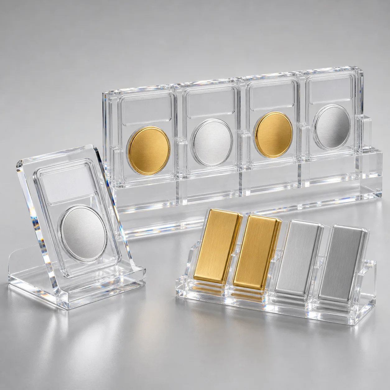 Studio lineup of clear acrylic coin display cases — a single-coin slab stand, a multi-slot coin block, and a wall-mount coin rack, each holding graded coins and capsules