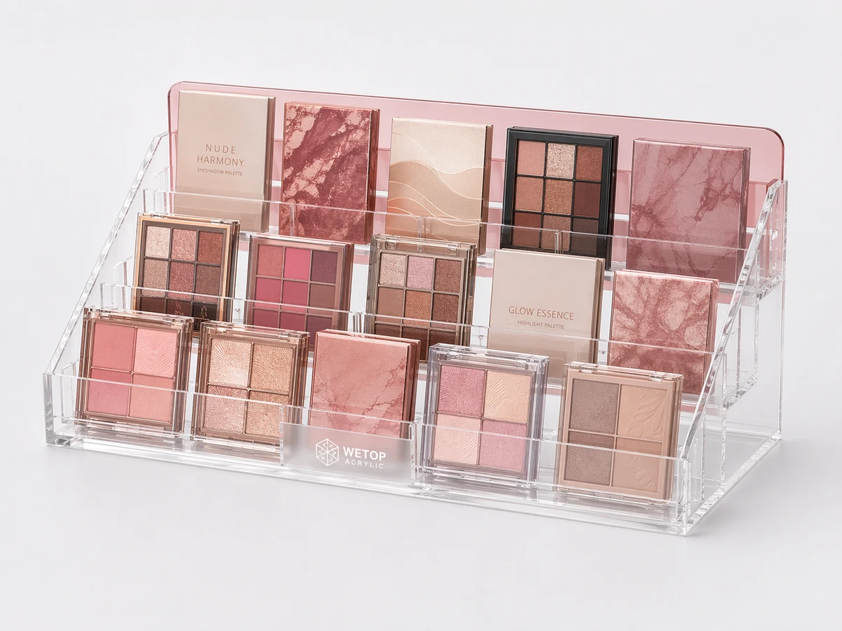Acrylic palette organizer with stepped shelves holding eyeshadow palettes upright