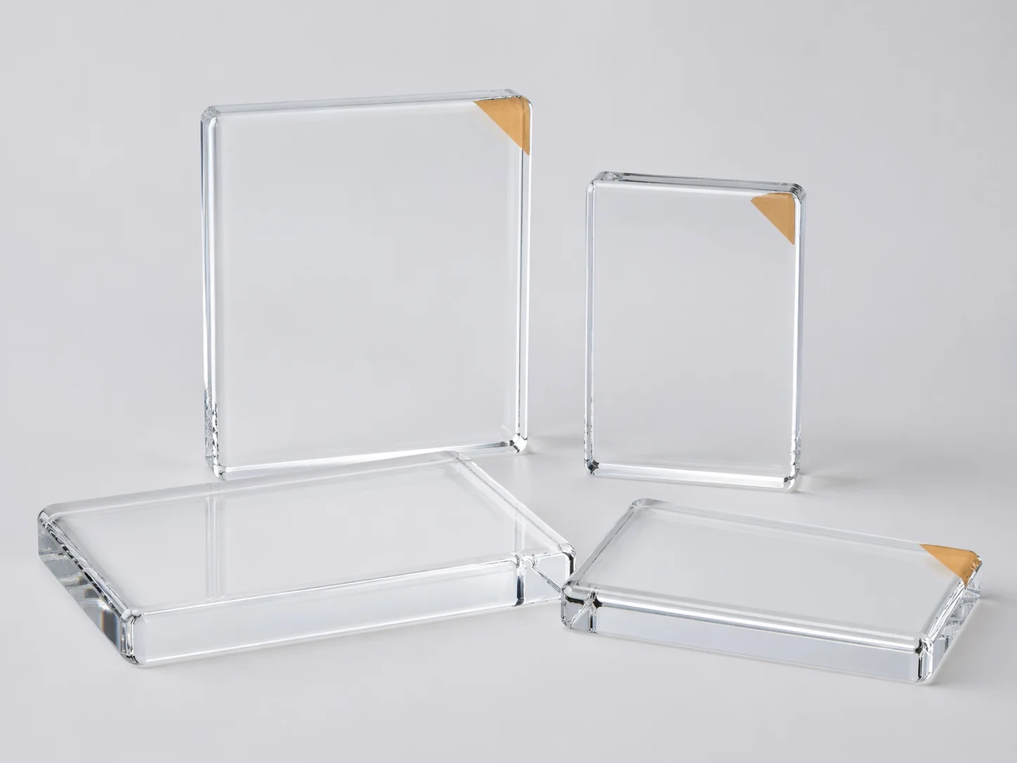 Blank acrylic photo blocks in multiple standard sizes with subtle protective film corner tabs on a light gray studio background