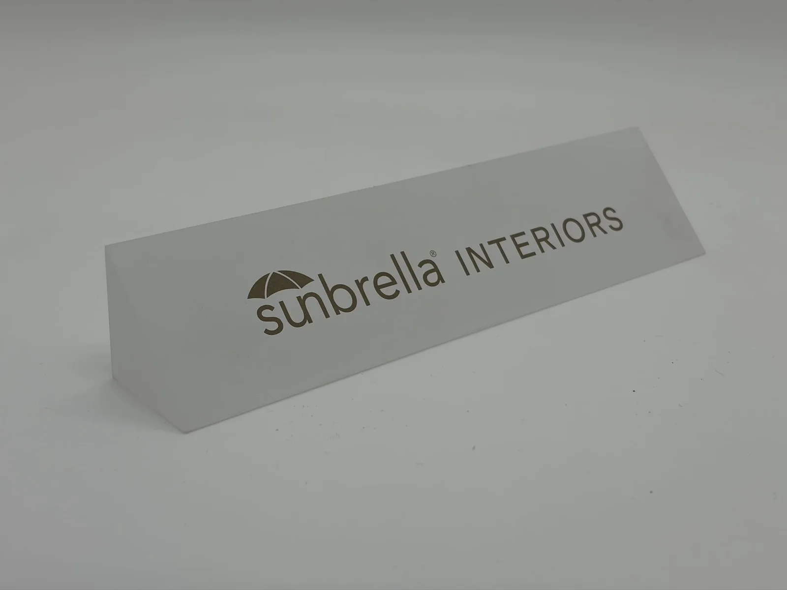 Frosted white acrylic logo block with single-color interior brand mark